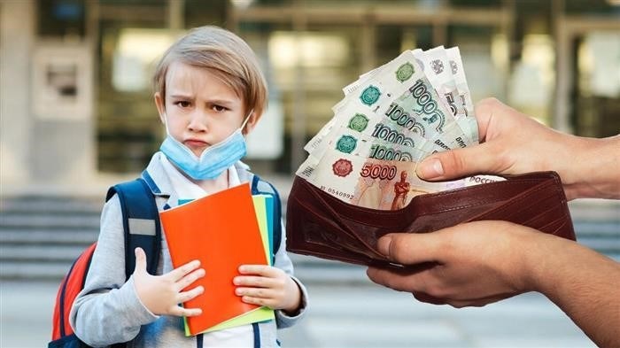 Мальчик, стоящий рядом со школой, несет на плече свой рюкзак, которым заполнены тетрадки. В его кошельке находятся монеты и банкноты.